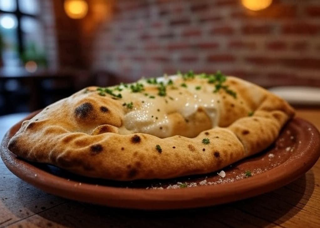 Un calzone diferente, con queso de cabra fundido Calzone con queso de cabra y cebolla caramelizada